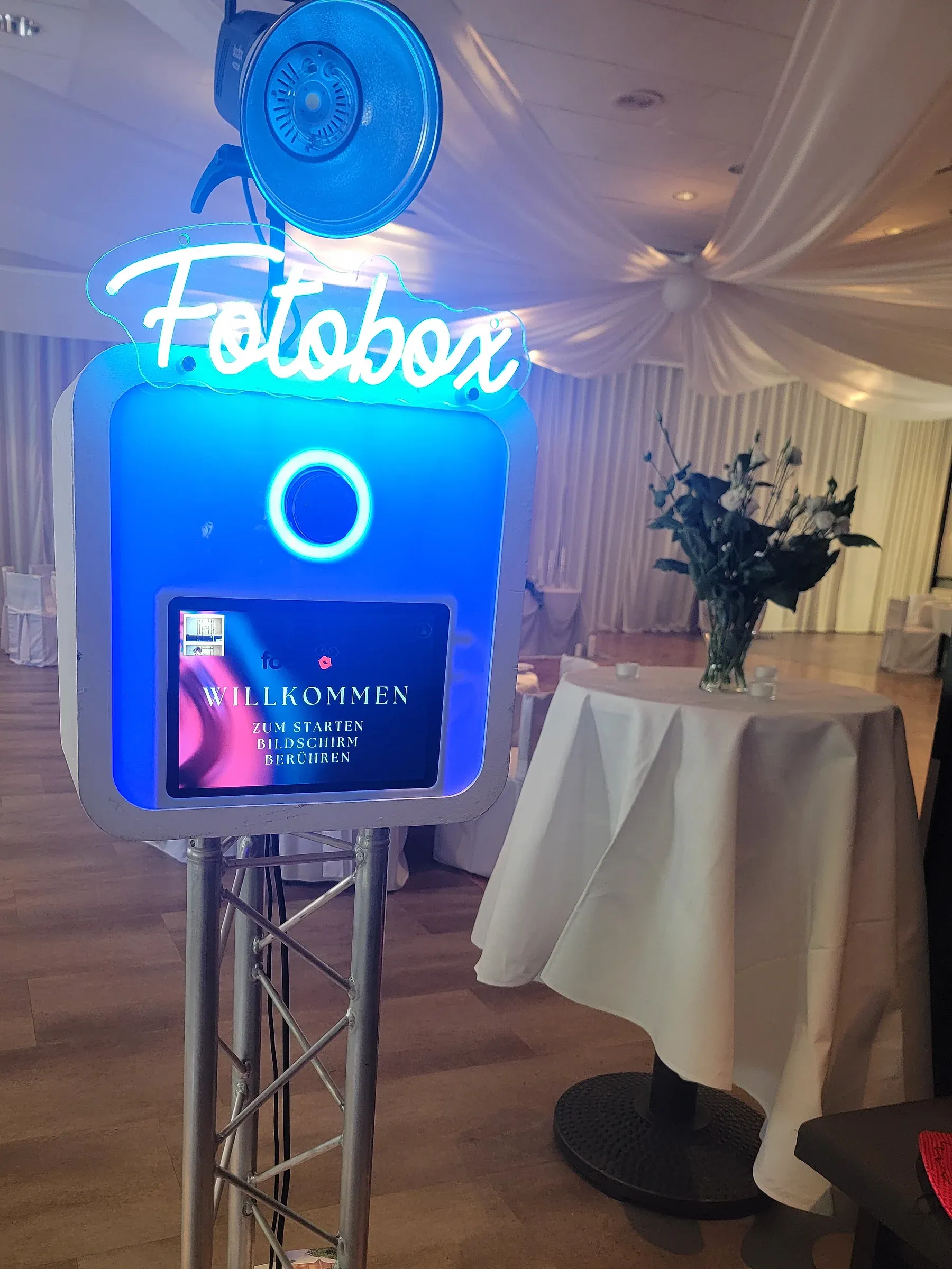 Fotobox mieten Bielefeld: Fotobox mit Neon-Schriftzug und Studioblitz im festlich dekorierten Hochzeitssaal