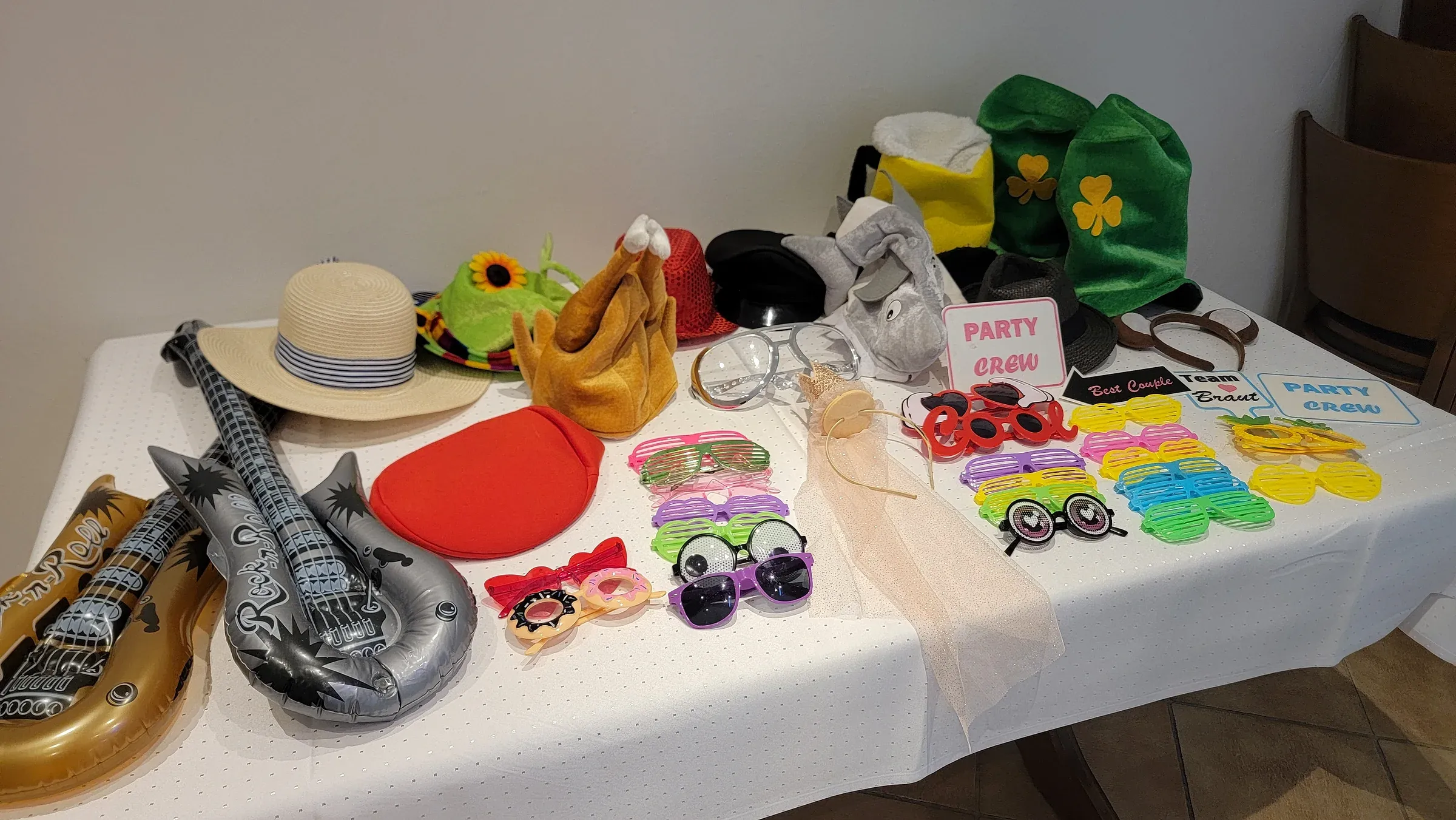 Requisiten-Tisch mit Hüten, Brillen, Gitarren und Schildern – Fotobox mieten Bielefeld mit Requisiten inklusive